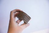 Side view of the vintage African cuff's substantial thickness and aged, textured surface.