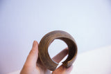 Profile of a handmade African cuff bracelet highlighting its thick, open form.
