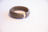 Profile view of a vintage African cuff bracelet highlighting its texture and open shape.