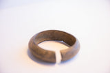 Vintage African cuff bracelet opening detail, showing its thick metal and aged patina.