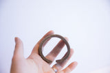 Vintage handmade African cuff bracelet held in-hand, showing its scale and patina.