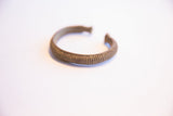 A collectible African currency bracelet with a textured, ribbed surface.
