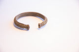 Ribbed texture and distinct capped ends of the vintage African cuff.