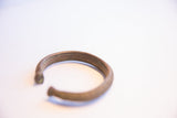 The open ends and curved shape of the vintage African cuff bracelet.
