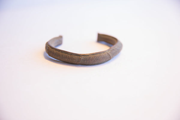 Curved profile of the vintage African cuff bracelet with its textured patina.