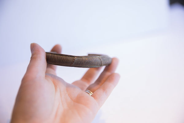 Detailed side view of the vintage African cuff, highlighting its solid build and textured surface.