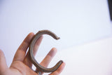 Vintage African cuff bracelet held in hand to demonstrate scale.