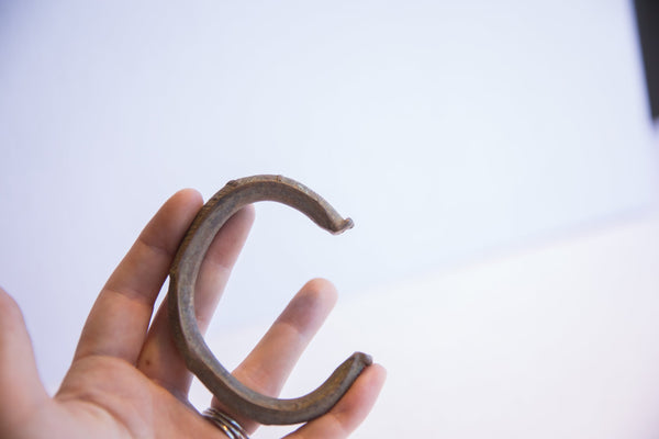 Vintage African cuff bracelet held in hand to demonstrate scale.