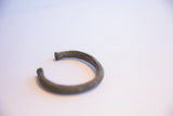 Angled view of the vintage African cuff's rustic, patinated metal and open form.