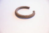 The open form and ribbed, aged surface of the vintage African cuff bracelet.