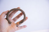 Vintage African cuff bracelet held in hand, showing its circular shape and scale.