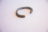 Angled view of the vintage African cuff showing its C-shape and oxidized texture.
