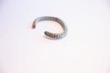 View of the open form and textured ends of the vintage oxidized cuff bracelet.