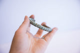 The ribbed texture and time-softened green patina of the vintage African cuff.
