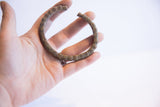 Vintage African currency cuff with a segmented design held in hand.