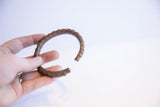 The scale and form of the vintage African cuff bracelet seen held in hand.