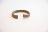 Close-up of the vintage African cuff's open ends, revealing the aged metal and fine texture.