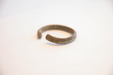 Angled view of the vintage African cuff bracelet's opening, revealing its textured patina.