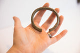 Vintage African cuff bracelet held in hand, showing its scale and aged patina.