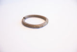 Vintage African cuff bracelet showing its weathered patina and incised line details.