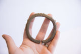 Vintage African cuff bracelet held in hand, showing its textured patina and form.