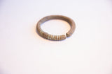 Angled view of the vintage African currency bracelet, showing its open form and oxidized texture.