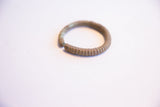 The ribbed texture and time-softened patina of the collectible African cuff bracelet.