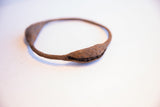 Detail of the handcrafted Yoruba rattle showing its deep, oxidized metal texture.