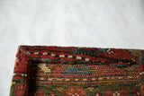 Reverse view of the framed decorative rug art showing its sawtooth hanger and woven texture.