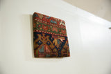 Side profile of the framed antique Kurdish rug art, showing its dimensional depth.