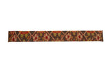 Decorative antique Karabagh rug art with a repeating geometric floral design in red, green, and pink on a dark field.