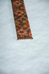 The hand-knotted texture and finished edge of a decorative antique Karabagh rug fragment.