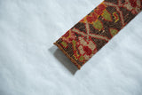 The handwoven texture and finished corner of a decorative antique Karabagh rug fragment.