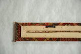 Back of the framed antique rug art revealing the wooden stretcher and wall hanger.