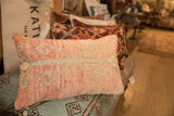 Textured vintage rug fragment pillow in soft peach and light blue geometric motif.