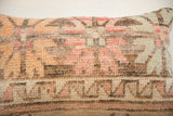 Hand-knotted Vintage Rug Fragment Pillow, with muted geometric patterns in orange, pink, and brown.