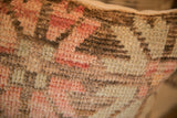 Textured hand-knotted pile of vintage rug fragment in muted pink, cream, and brown.