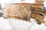 Vintage rug fragment pillow, textured weave with aged, muted linear pattern.