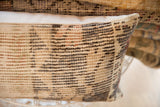 Textured vintage rug fragment pillow showcasing muted striped pattern and age-softened colors.