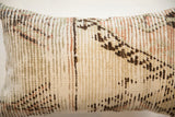 Textured weave of the reclaimed vintage rug fragment showing earthy sage, rose, and brown details.
