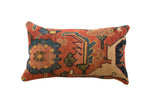 Antique Persian Bijar rug fragment pillow features dense, intricate terracotta, sapphire blue, and gold motifs.