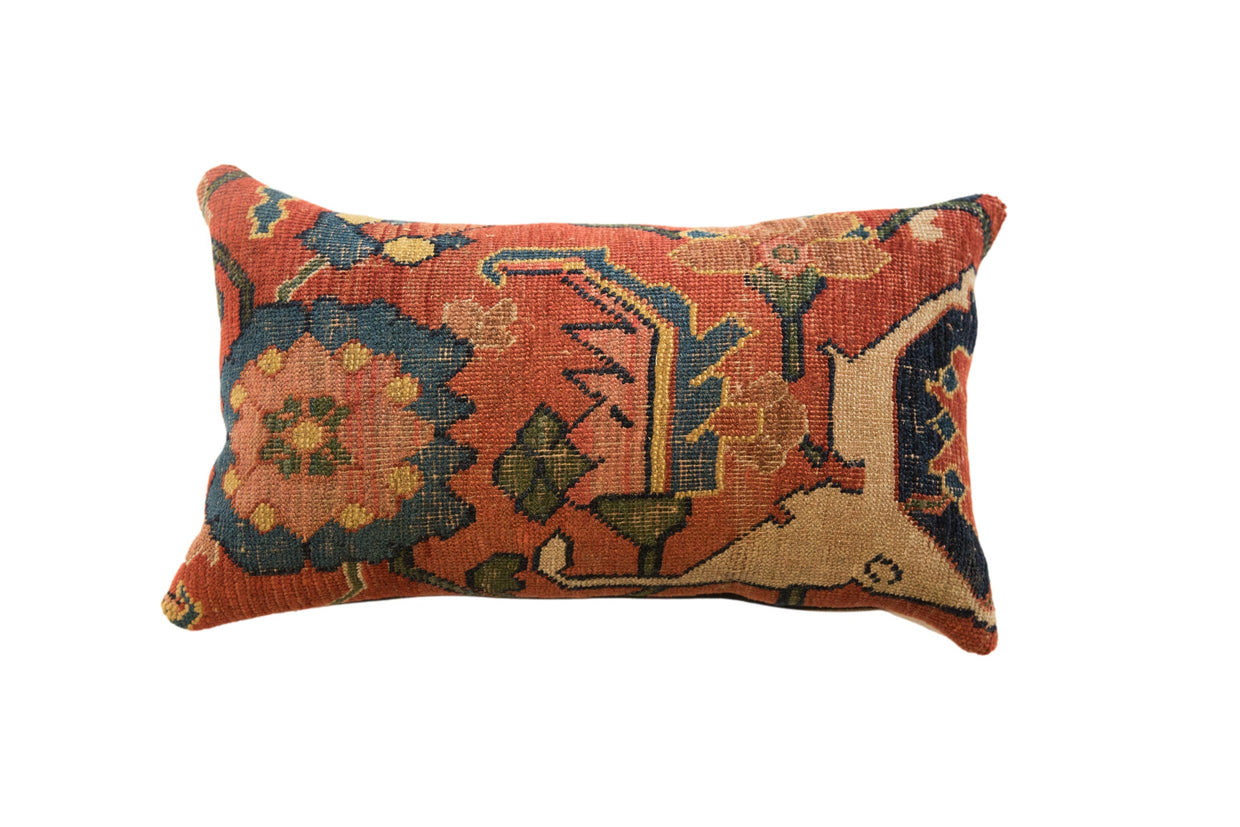 Antique Persian Bijar rug fragment pillow features dense, intricate terracotta, sapphire blue, and gold motifs.