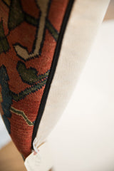 Antique Bijar rug pillow showing textured rust and green patterns, black zipper, neutral backing.