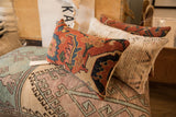 Aged Bijar rug fragment pillow with geometric design in rust, indigo, and beige.