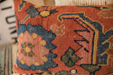 Antique Bijar pillow fragment's hand-knotted texture with terracotta, blue, gold geometric motifs.