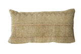 Vintage Persian rug fragment pillow in sandy beige with a woven texture and geometric zigzag border.