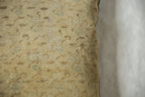 Vintage Turkish Sivas pillow with muted beige tones, faded green pattern, and visible foundation.