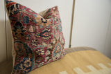Vintage Meshed pillow's side, showing intricate curvilinear border, burgundy, blue, ivory hues, and varying pile.