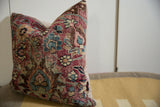 Textured surface of vintage Meshed pillow with red, sky blue, and ivory floral motifs.