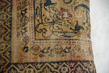 Detailed weave of an antique rug pillow with art nouveau serpent blossom in saffron and teal.